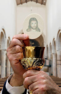 Priest Holding a Consecrated Host - The body and Blood of Christ