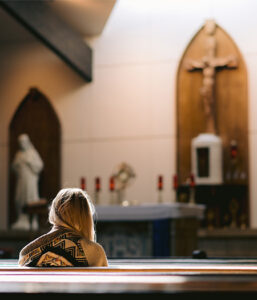 Girl in Church before the Monstrance at Eucharistic Adoration where Christ is Truly Present