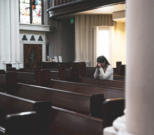 Young lady spending sacred time with Jesus in a church